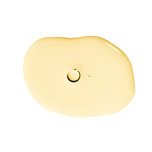 Small puddle of Vitamin E oil on a circular, white backdrop